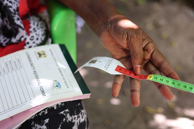 Mwanamkasi Hassan, a community health Promoter [CHP] in Kasarani village in Kilifi county, displaying a MUAC bracelet which helps mothers recognise signs of malnutrition in their children [Marion Kithi]